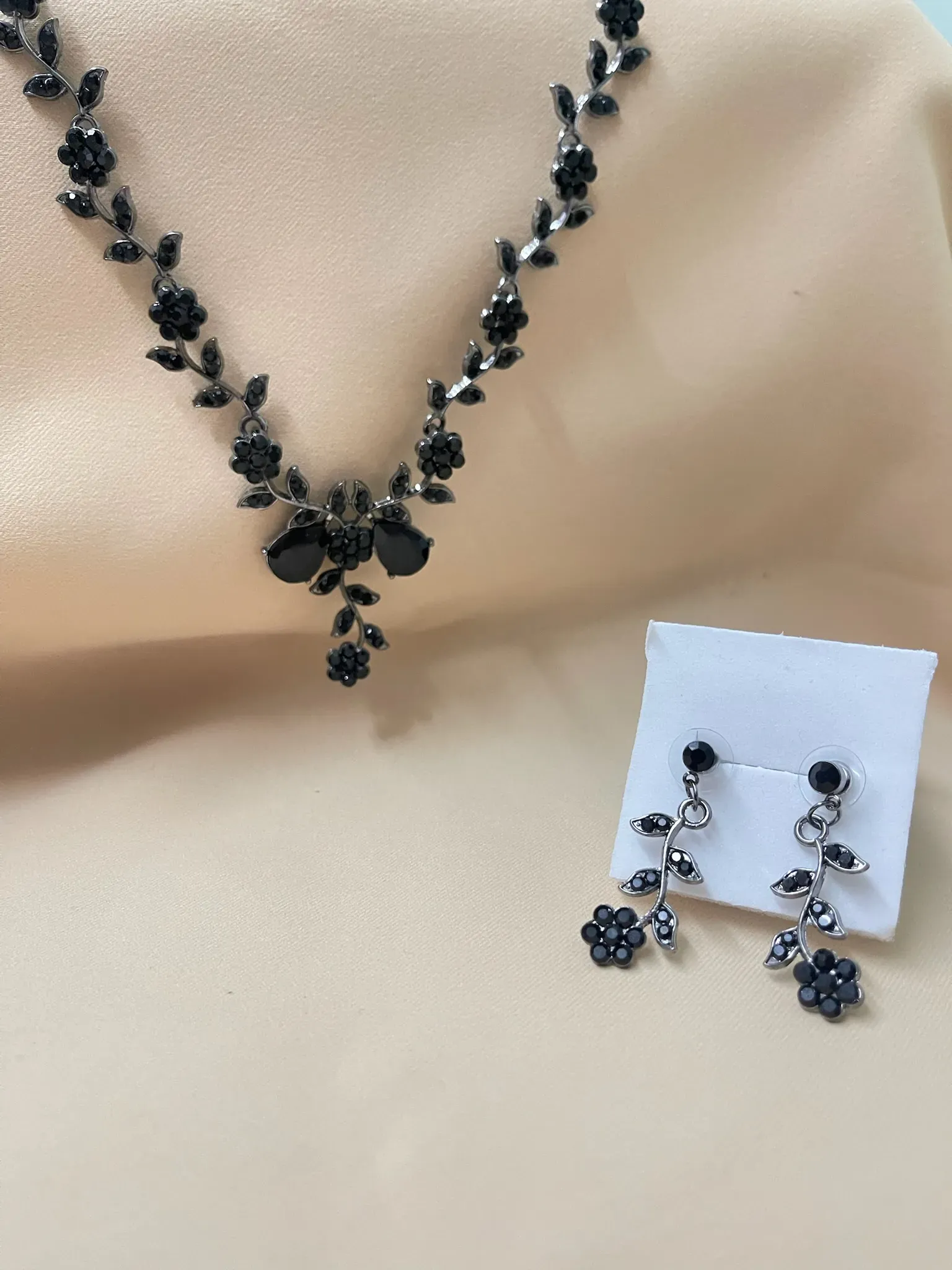 Collar y aretes con flores negras, un conjunto moderno y elegante.